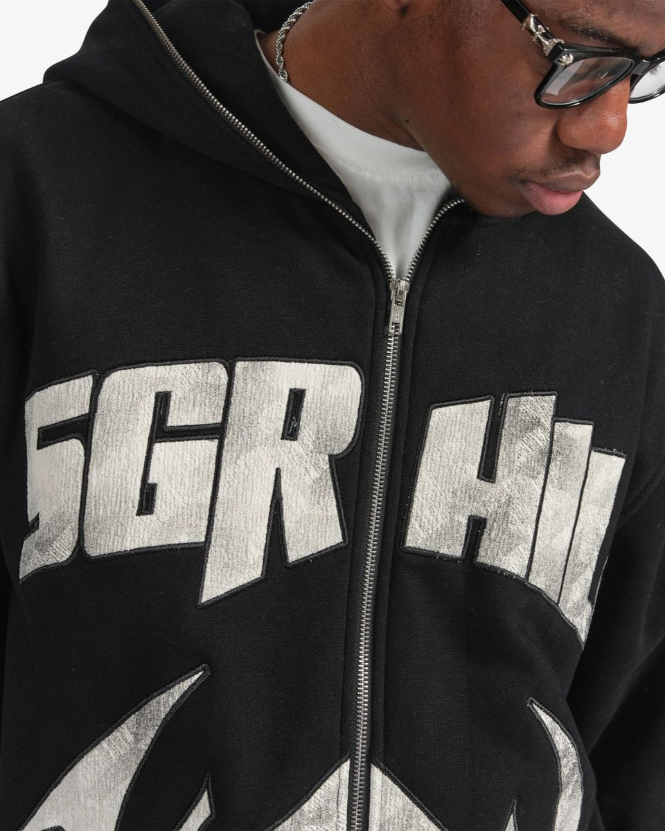 Person wearing a black hoodie with 'SGR HI' printed on it, looking down.