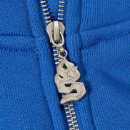 Close-up of a blue jacket zipper with a decorative silver pull