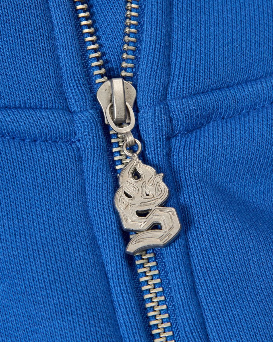 Close-up of a blue jacket zipper with a decorative silver pull