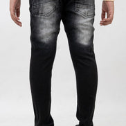 Person wearing black distressed jeans on a white background