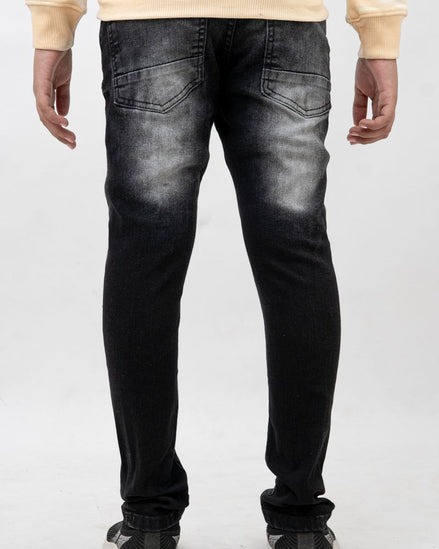 Person wearing black distressed jeans on a white background