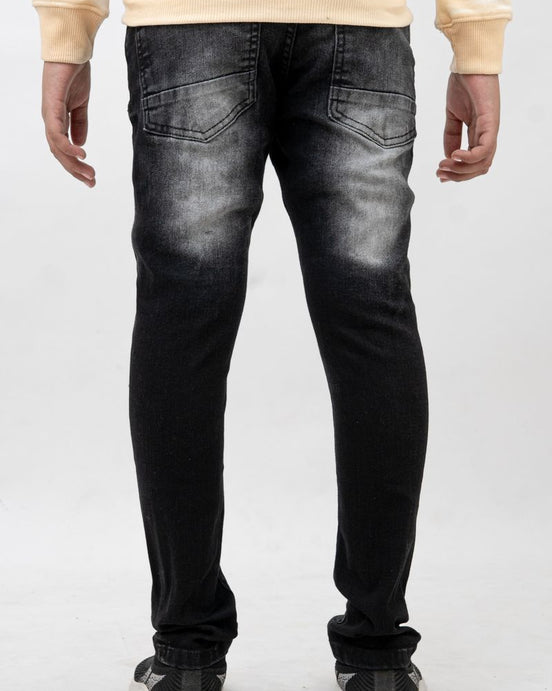 Person wearing black distressed jeans on a white background