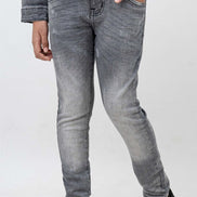 Person wearing gray jeans and black shoes on a white background