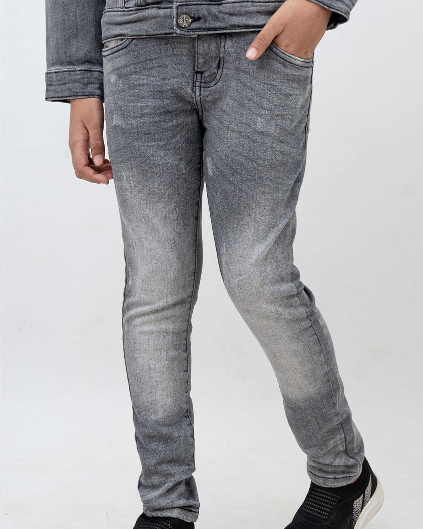 Person wearing gray jeans and black shoes on a white background