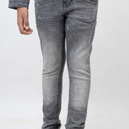 Person wearing gray jeans and black shoes on a white background
