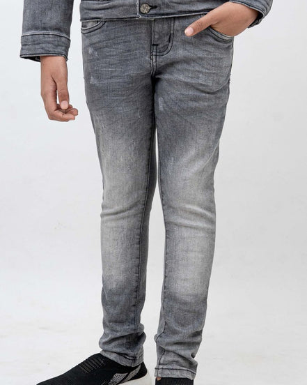Person wearing gray jeans and black shoes on a white background