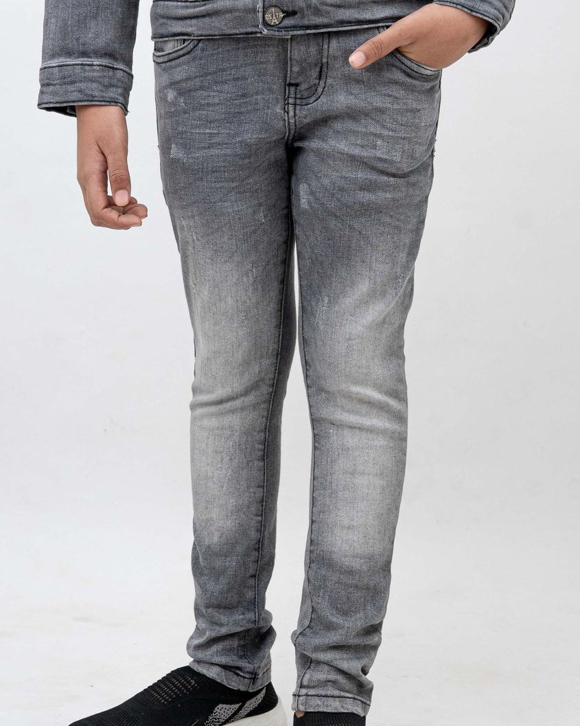 Person wearing gray jeans and black shoes on a white background