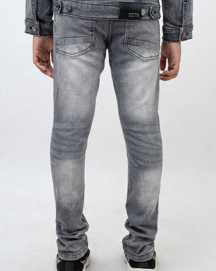 Person wearing gray jeans and a denim jacket on a white background