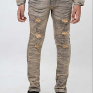 Distressed beige jeans worn by a person on a white background