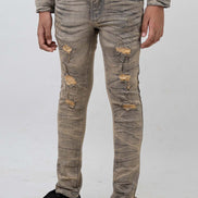 Person wearing distressed beige jeans on a white background