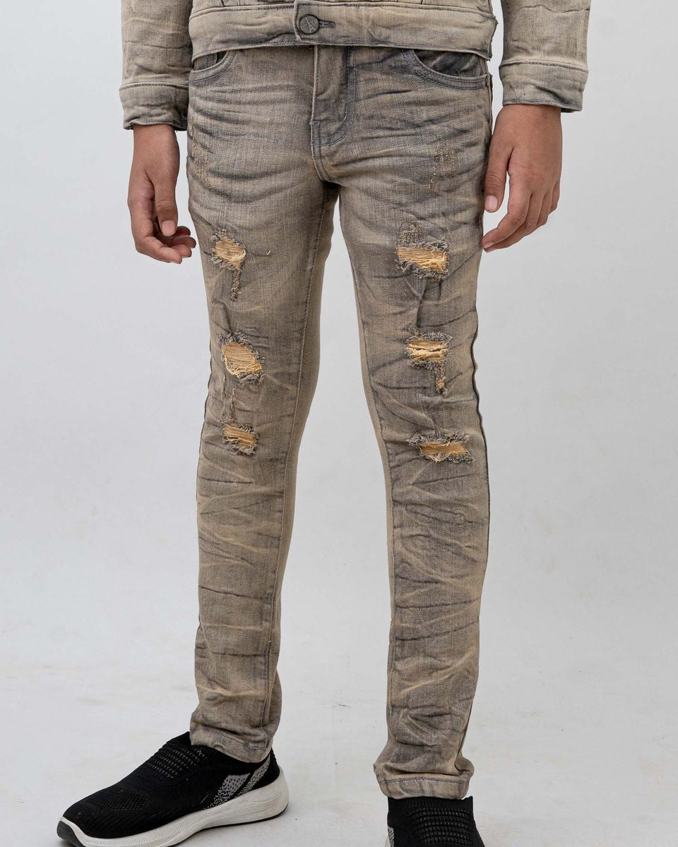 Person wearing distressed beige jeans on a white background