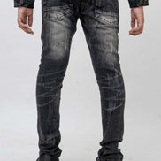 Black distressed jeans worn by a person on a white background