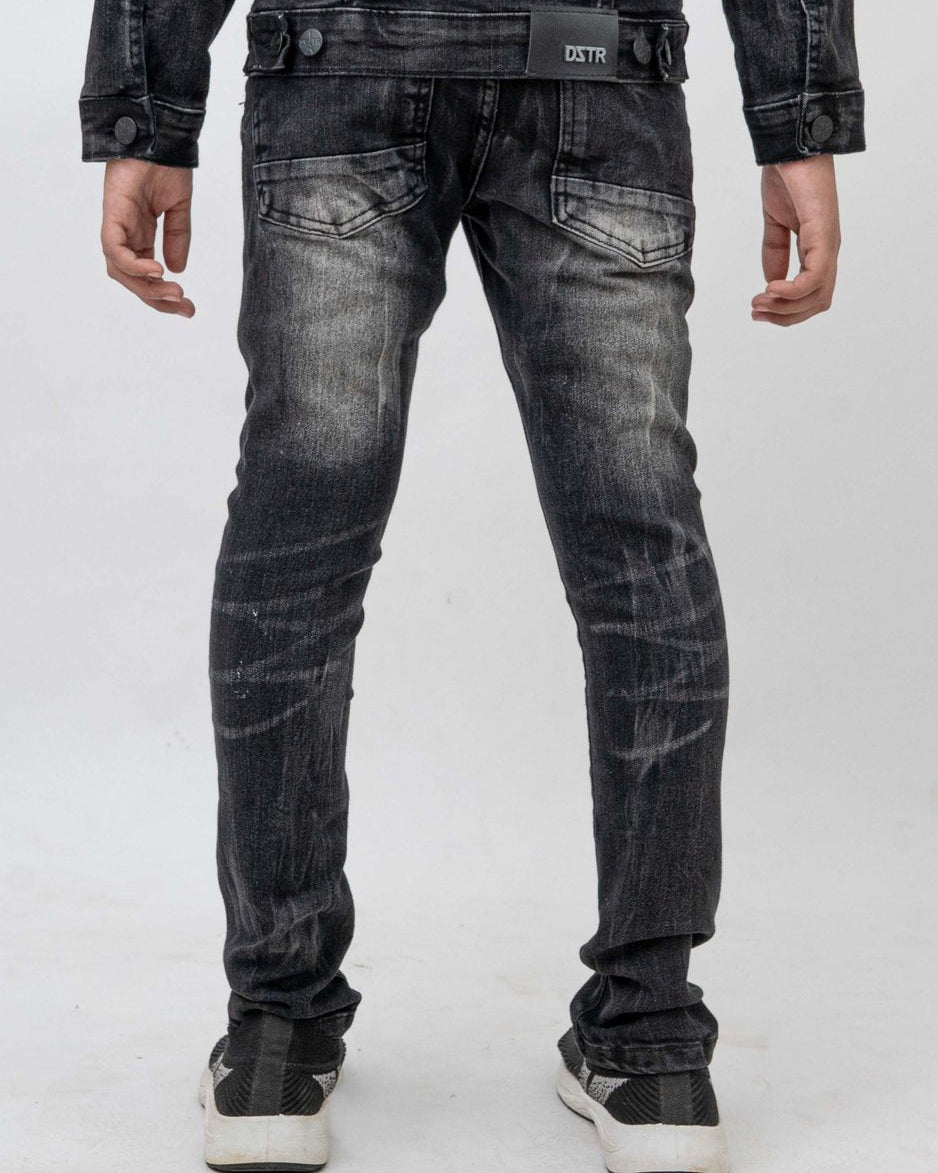 Black distressed jeans worn by a person on a white background