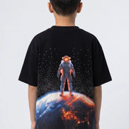 Black t-shirt with an astronaut on a planet design, worn by a person against a white background