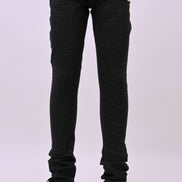 Person wearing black rhinestone pants and white sneakers on a white background