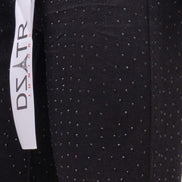 Black pants with white polka dots and a visible brand label on a black background