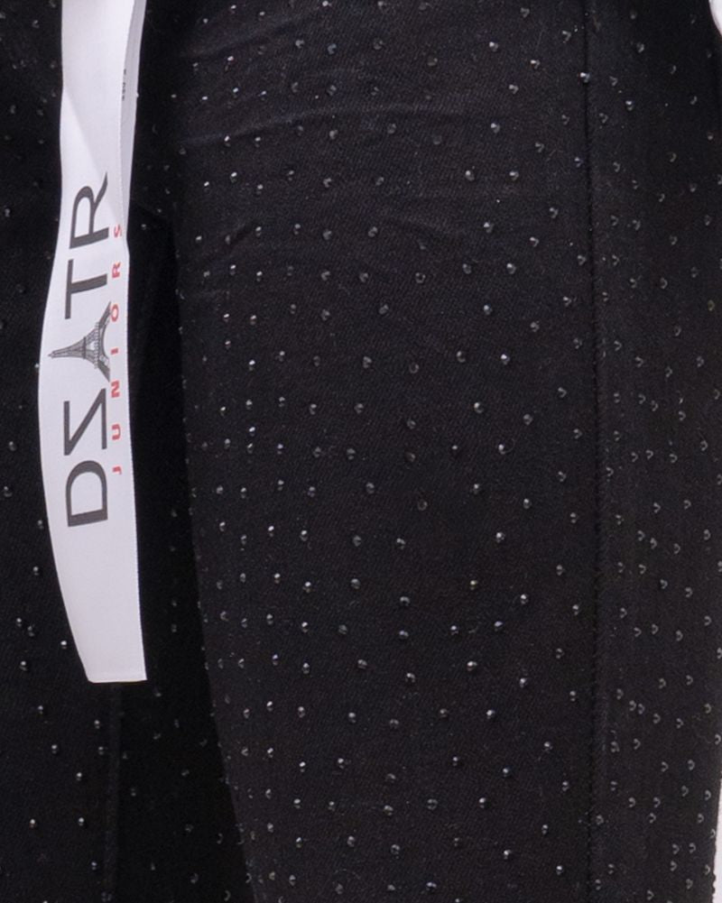 Black pants with white polka dots and a visible brand label on a black background