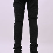 Person wearing black jeans and white sneakers on a white background