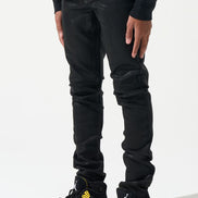 Person wearing black pants and black and yellow sneakers on a white background