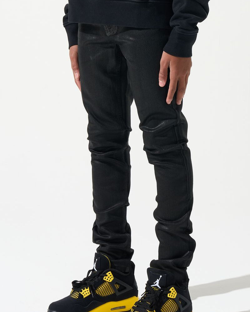 Person wearing black pants and black and yellow sneakers on a white background