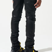 Person wearing black pants and black and yellow sneakers on a white background