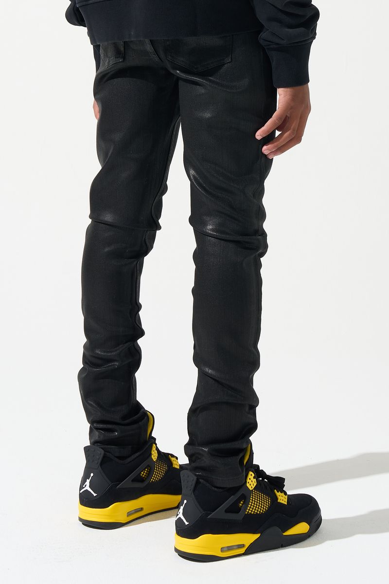 Person wearing black pants and black and yellow sneakers on a white background