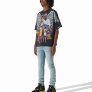 A person modeling a black graphic t-shirt with a Los Angeles Lakers print, paired with light-wash blue jeans and black and yellow sneakers, standing against a white studio background.