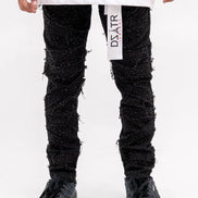 Person wearing black textured pants with a white label on a white background