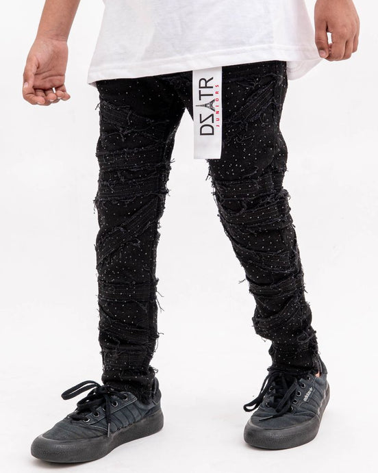 Person wearing black textured pants with a visible brand label on a white background