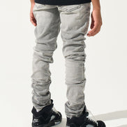 Person wearing gray jeans and black sneakers on a white background