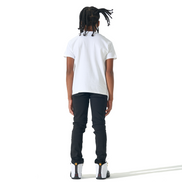 A child model shown from the back wearing a white short-sleeve t-shirt, black pants, and white sneakers, standing against a solid white background.