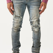 Person wearing distressed blue jeans and black and white sneakers on a white background