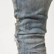 Close-up of a blue denim jeans with a brand logo on a white background