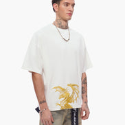 Man wearing a white t-shirt with a gold graphic design on a white background