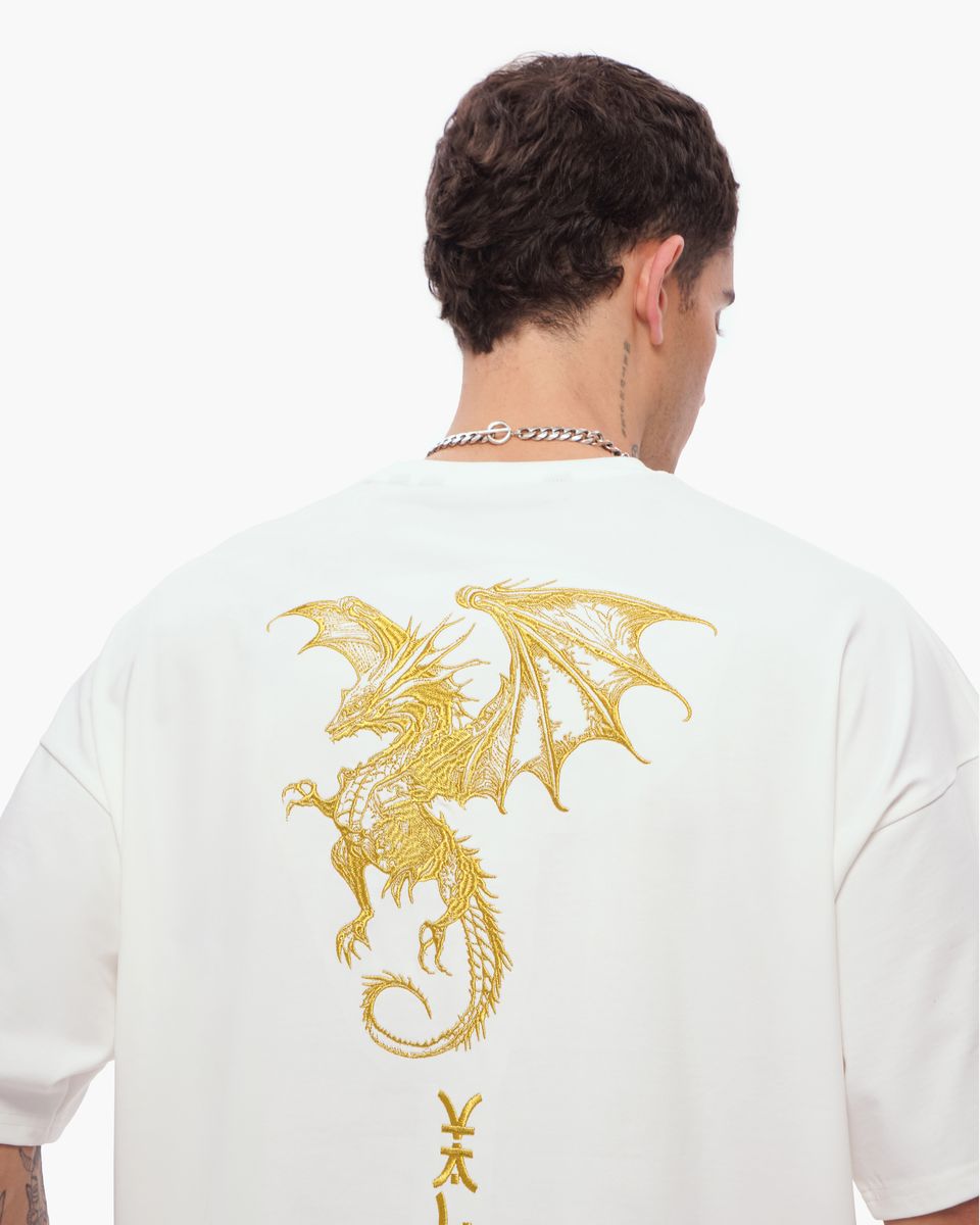 Person wearing a white t-shirt with a gold dragon design on the back against a white background