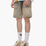 Person wearing beige denim shorts, white socks with a logo, and brown sneakers on a white background