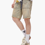 Person wearing beige shorts, white socks with a logo, and sneakers on a white background