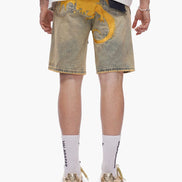 Person wearing light-colored denim shorts with yellow accents on a white background
