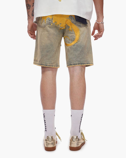 Person wearing light-colored denim shorts with yellow accents on a white background