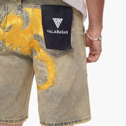 Denim shorts with a gold dragon design and Valabasas logo on a white background