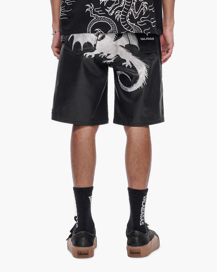 Person wearing black shorts with white dragon design on a white background
