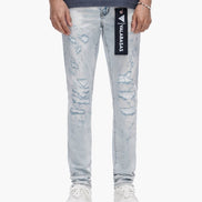 Person wearing light blue distressed jeans with a brand logo on a white background