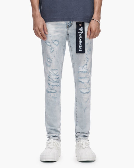Person wearing light blue distressed jeans with a brand logo on a white background