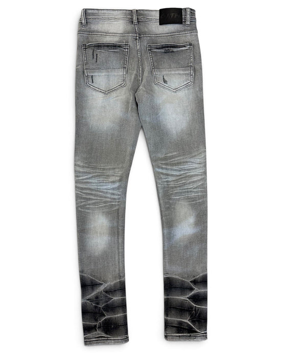 Gray denim jeans with a faded wash and a black reptile-scale pattern printed along the lower legs, shown from the back on a white background.