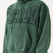 Green hoodie with 'CREED' text worn by a person on a white background