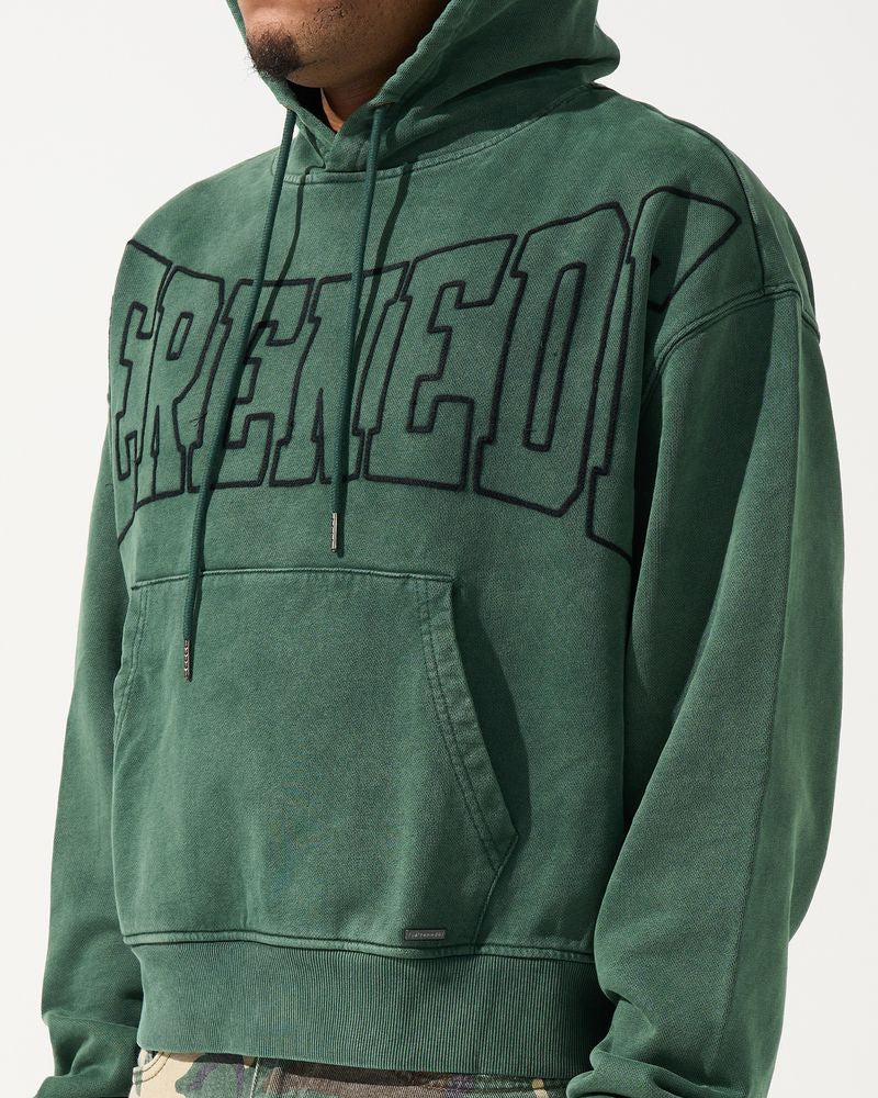 Green hoodie with 'CREED' text worn by a person on a white background