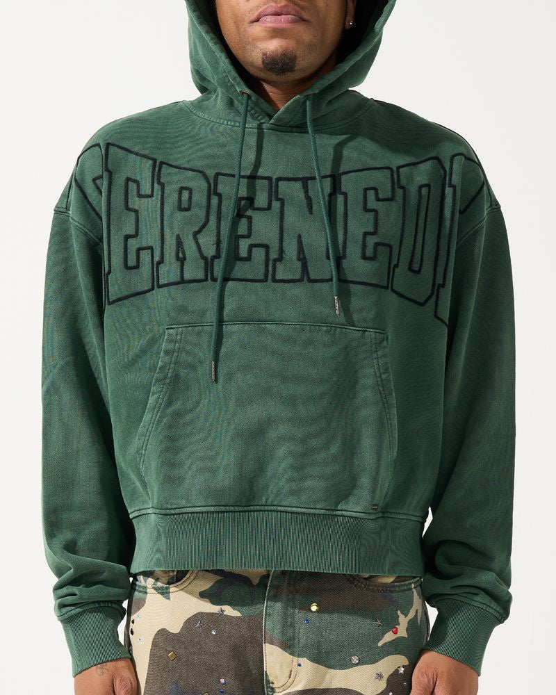 Person wearing a green hoodie with 'SERENEDE' printed on it, standing against a white background.