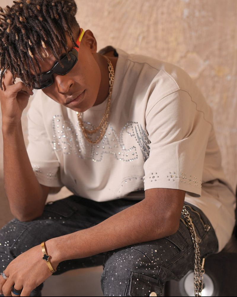 Person wearing a white sequin top and dark pants with a neutral background