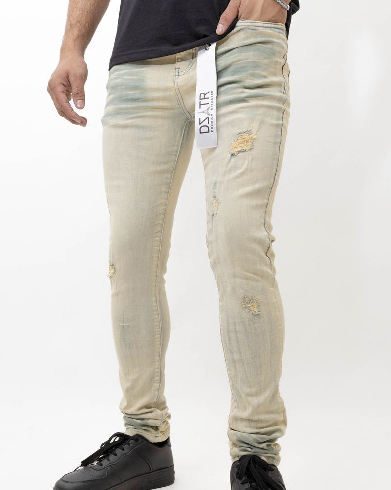 Person wearing light-colored distressed jeans with a visible brand label on a white background