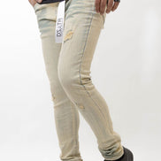 Person wearing beige distressed jeans with a visible brand label on a white background